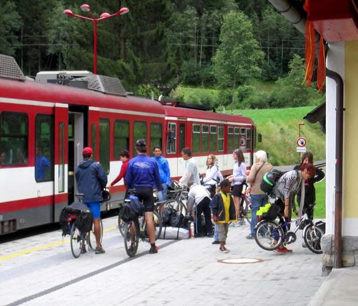 Leute am Bahnsteig mit Fahrrädern vor einem Zug