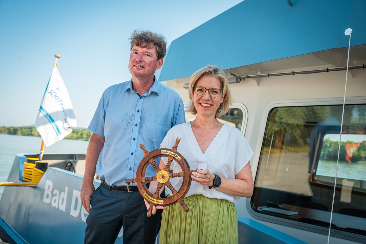 Bundesministerin Leonore Gewessler und Hans-Peter Hasenbichler vor einem Schiff