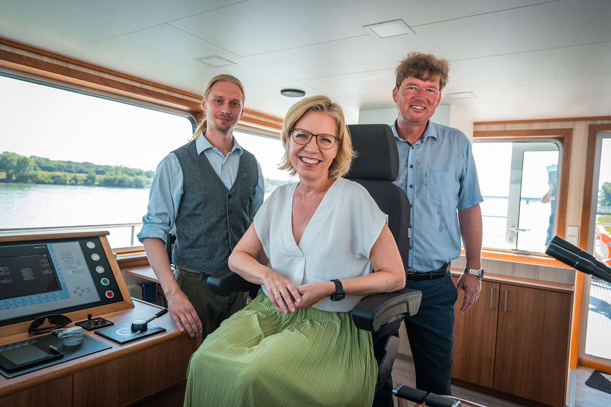 Bundesministerin Leonore Gewessler und Hans-Peter Hasenbichler mit einem Mitarbeiter im Schiff