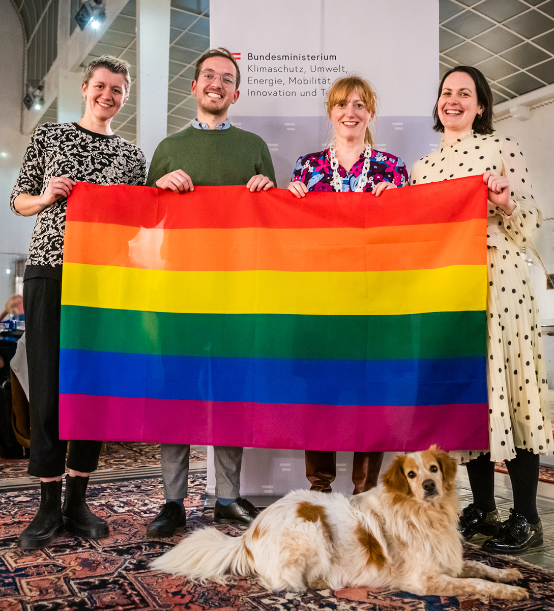 Eröffnungsveranstaltung von BunterBund: vier Personen halten die Regenbogenfahne, davor ein Hund